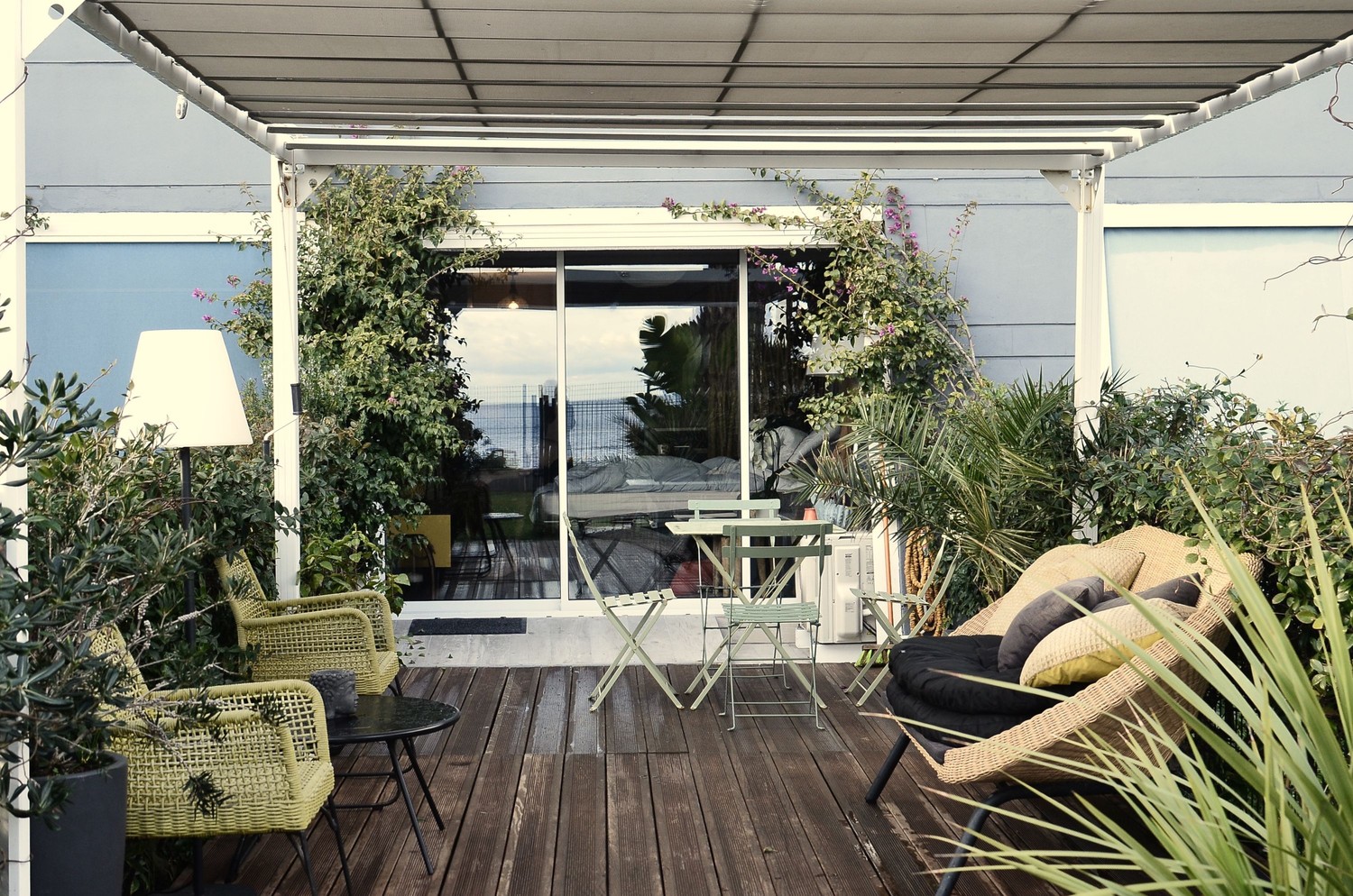 Zielone patio z rattanowym siedziskiem i drewnem fot. Pexels