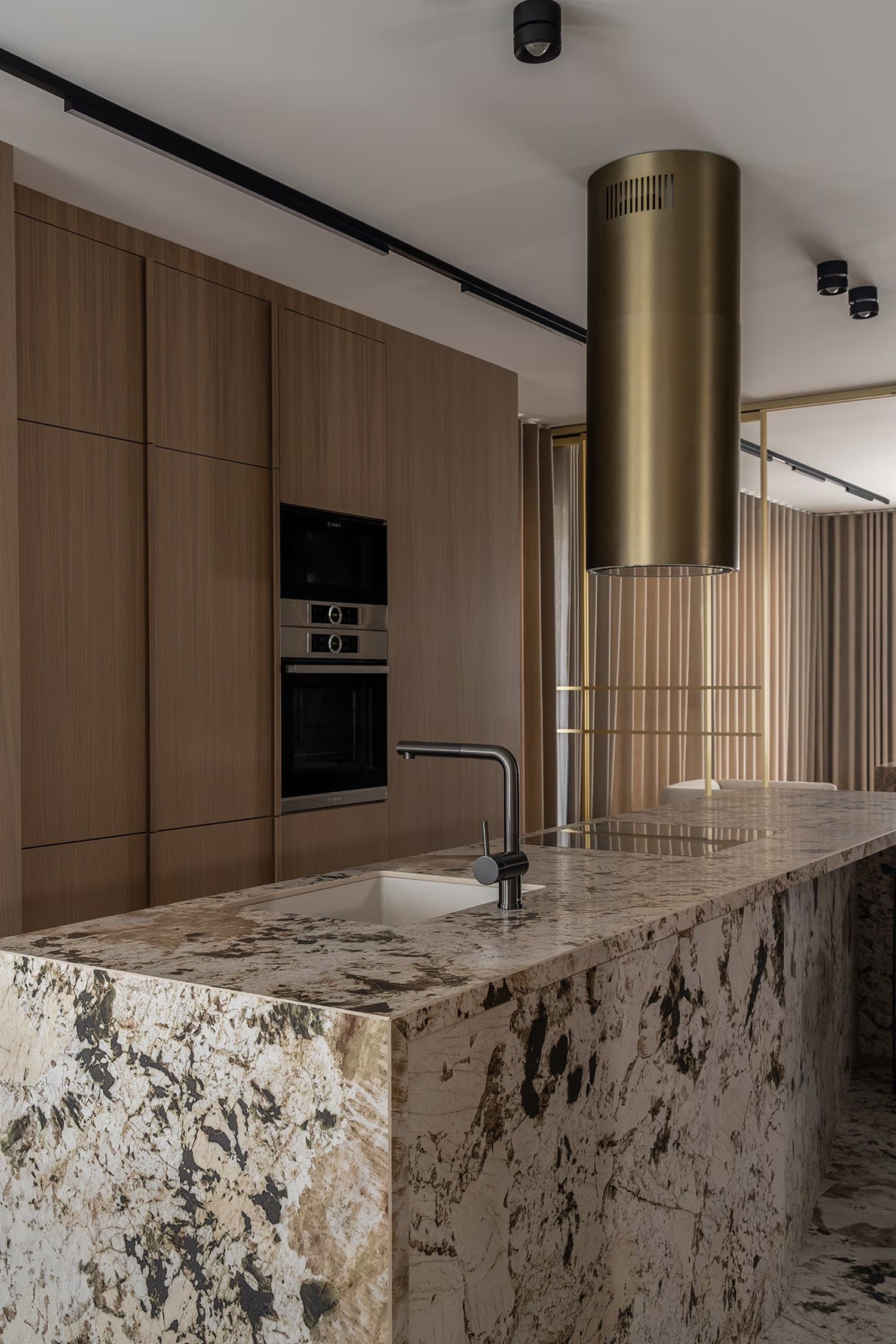 Minimalistyczna kuchnia z kamienną wyspą i drewnem. fot. Porcelanosa