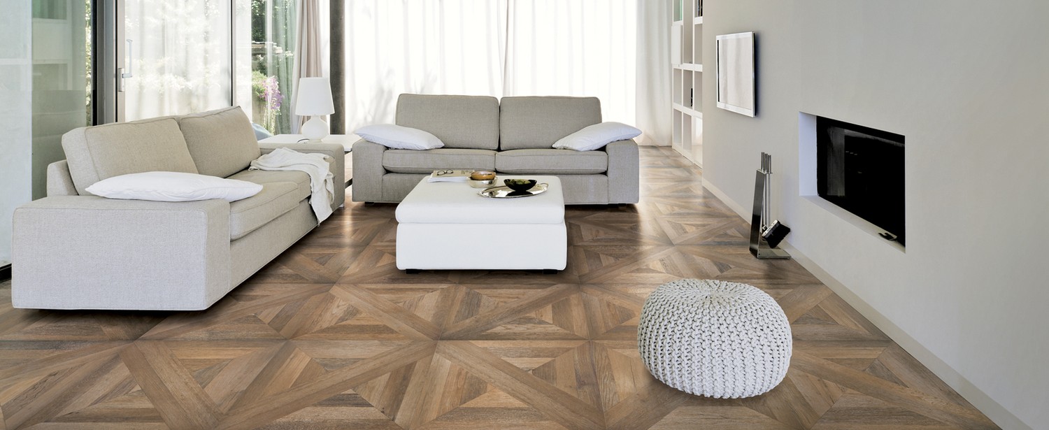 Jasny salon z geometryczną posadzką i kominkiem fot. Refin