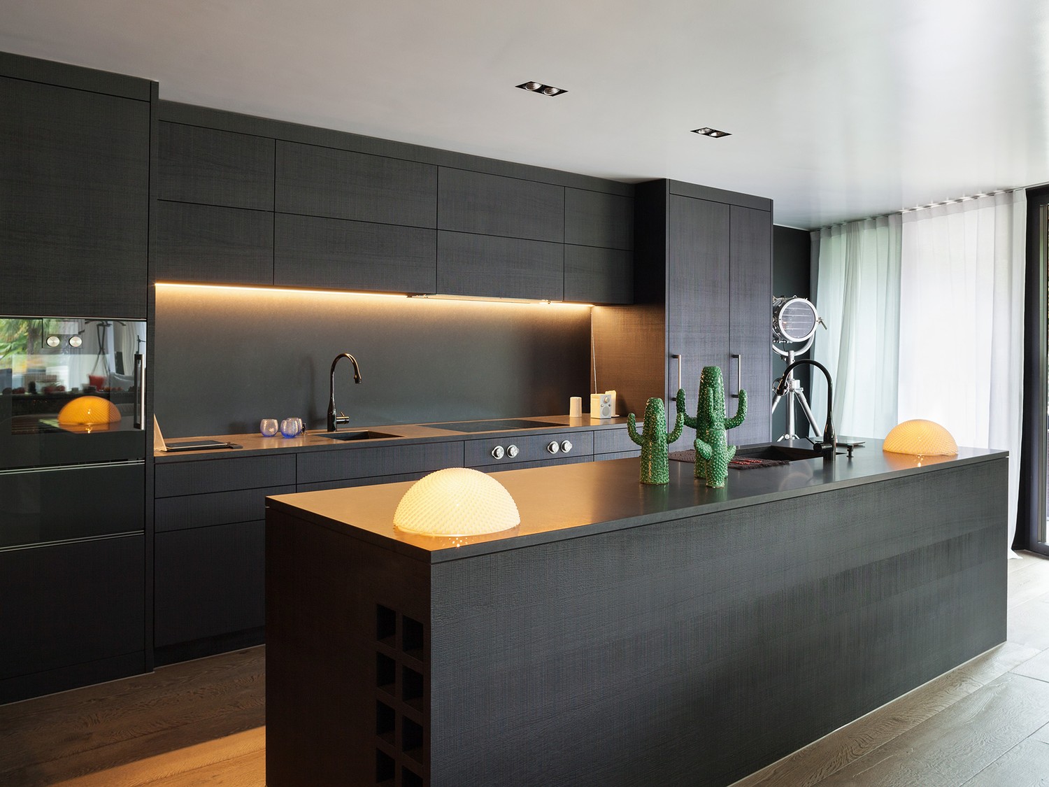 Czarna minimalistyczna kuchnia z wyspą i LED fot. Hansgrohe