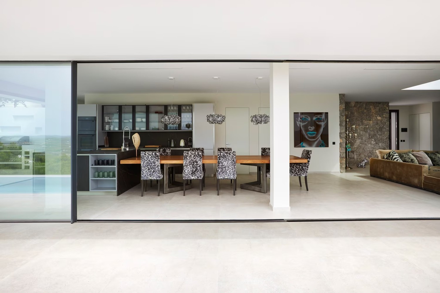 Minimalistyczna kuchnia z salonem i kamienną ścianą. fot. Porcelanosa