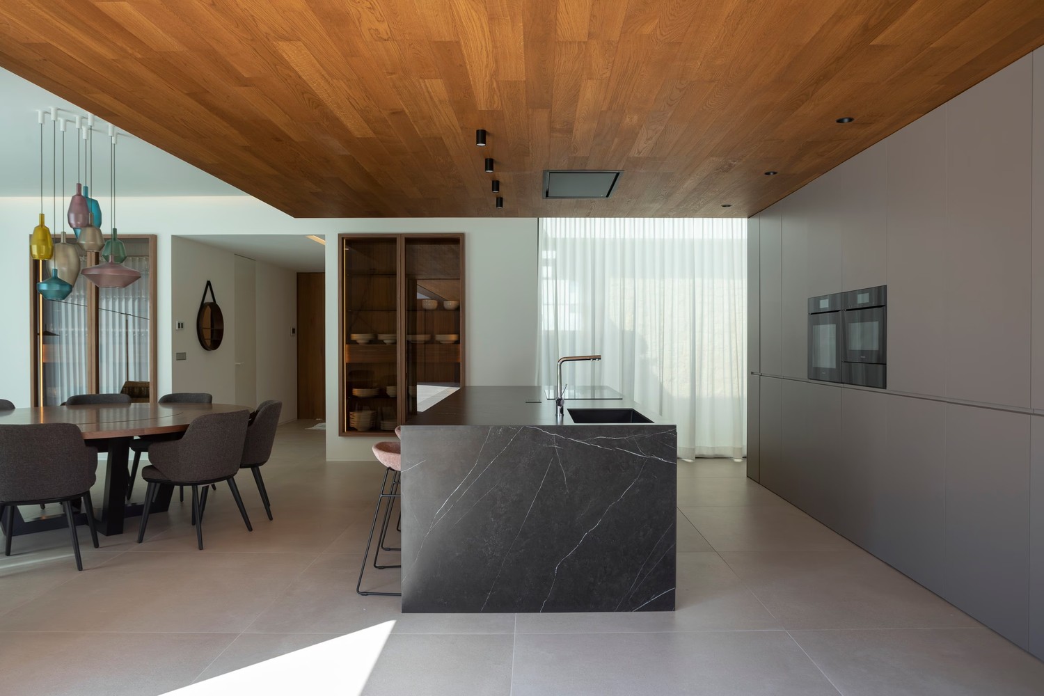 Minimalistyczna kuchnia z wyspą i drewnianym sufitem. fot. Porcelanosa