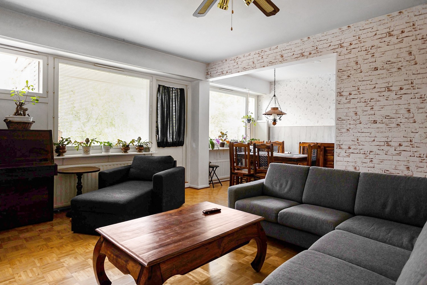Szary salon z jadalnią i ceglaną ścianą fot. Pexels