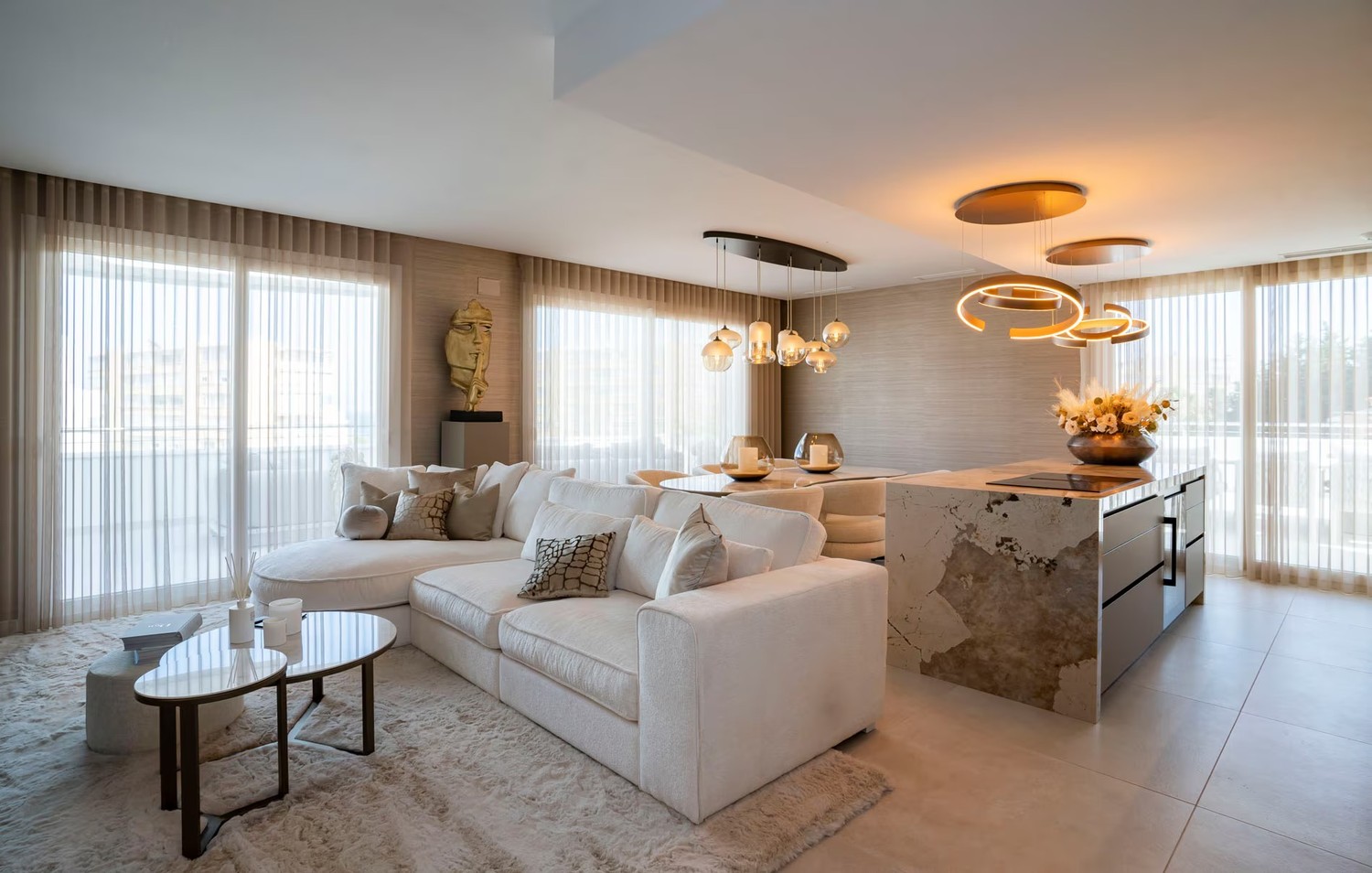 Elegancki salon z wyspą w jasnym beżu. fot. Porcelanosa