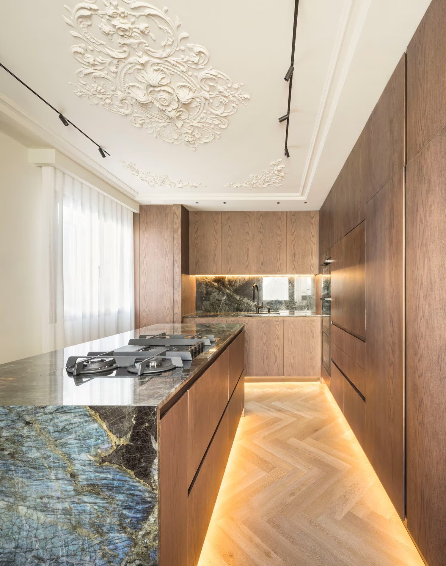 Kuchnia modern classic z marmurową wyspą i sztukaterią. fot. Porcelanosa