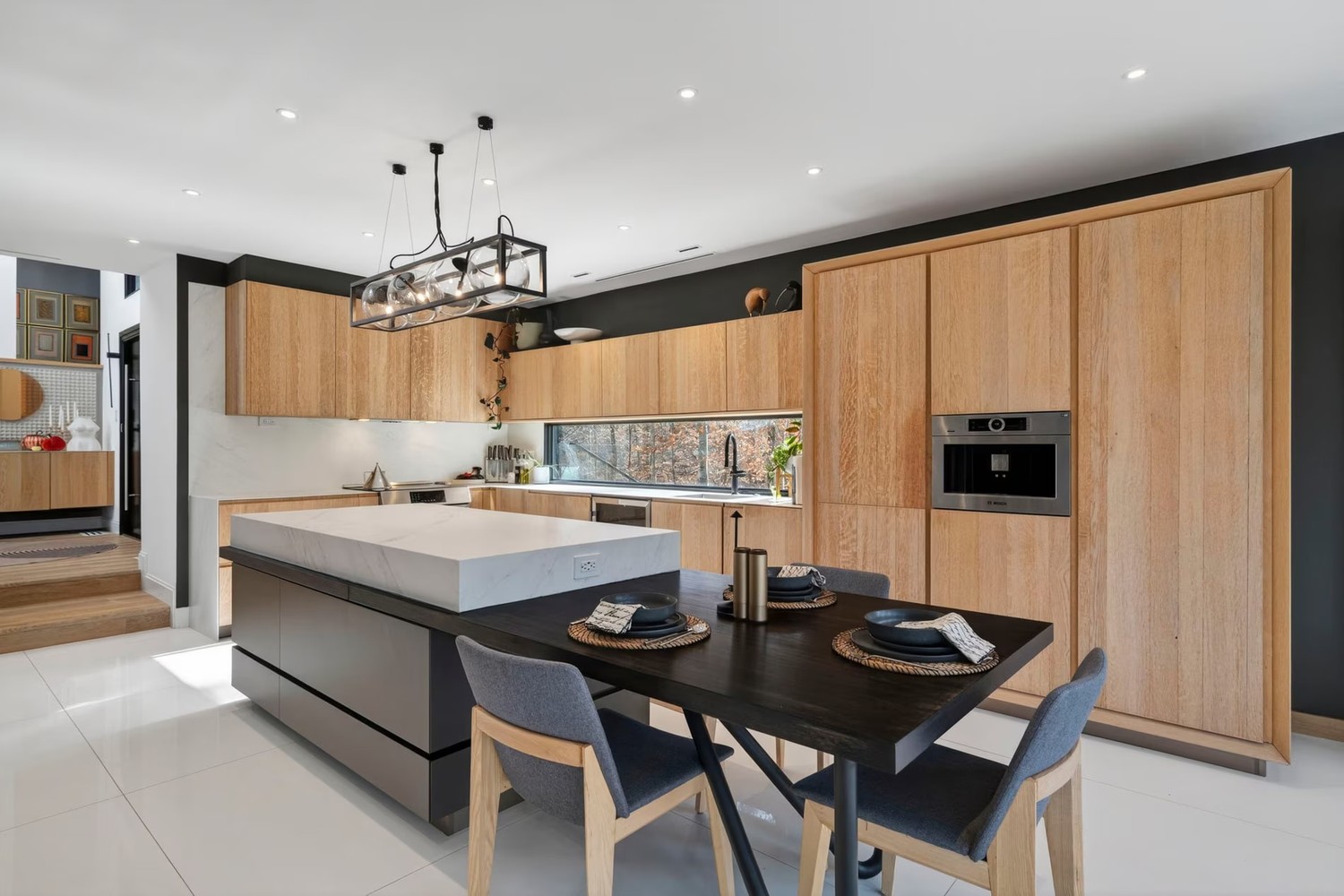 Minimalistyczna kuchnia z wyspą i drewnianą zabudową. fot. Porcelanosa