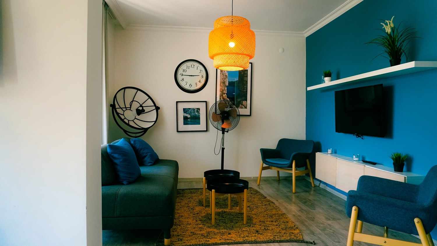 Nowoczesny salon z niebieską ścianą i fotelem fot. Pexels