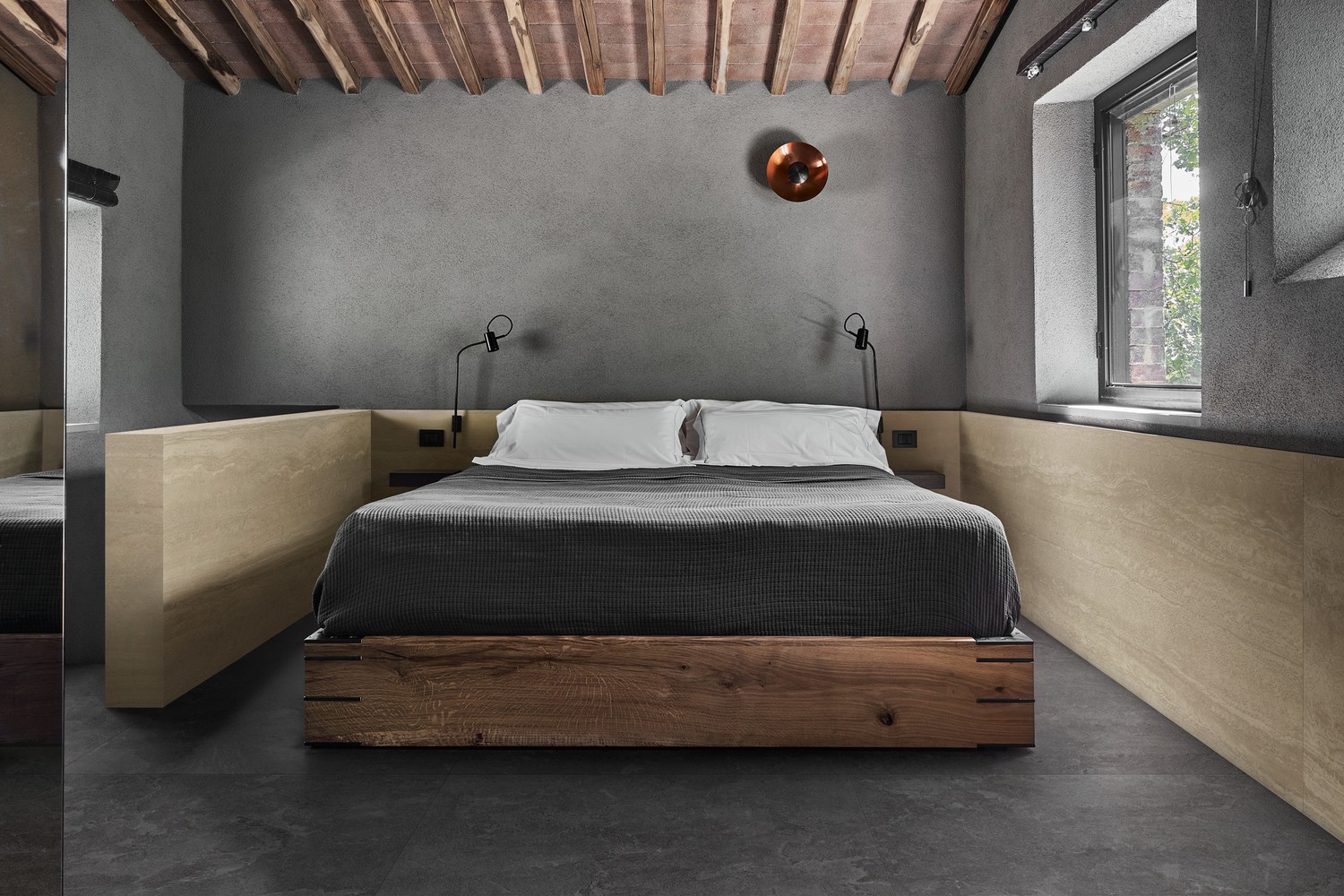 Minimalistyczna sypialnia z drewnianym łóżkiem i płytką. fot. Marazzi