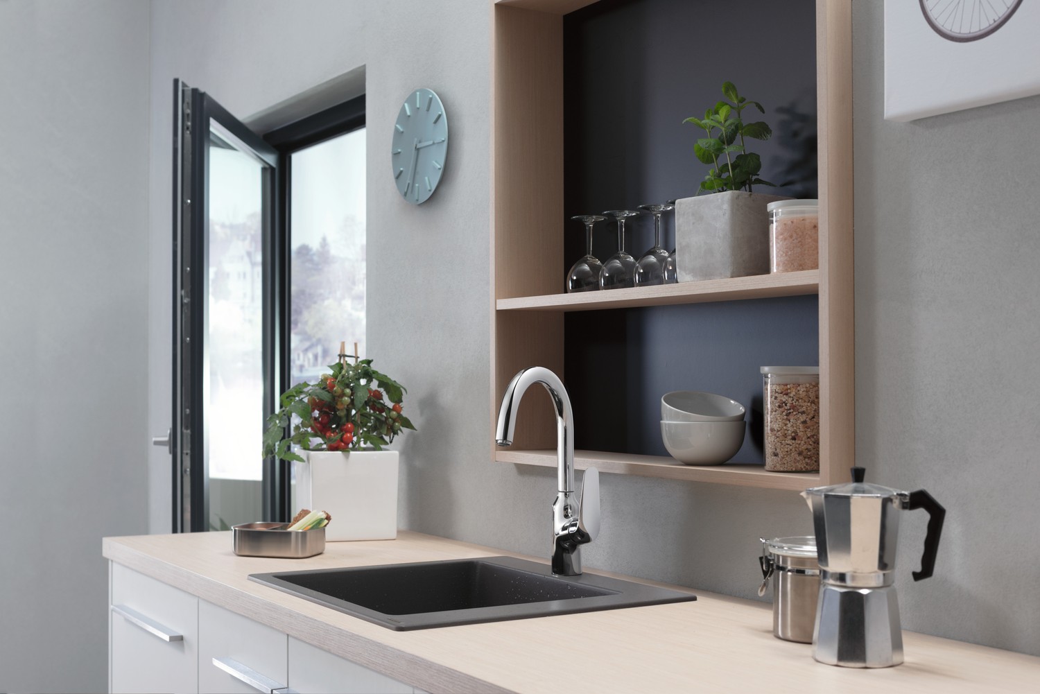 Minimalistyczna kuchnia z czarnym zlewem przy oknie fot. Hansgrohe