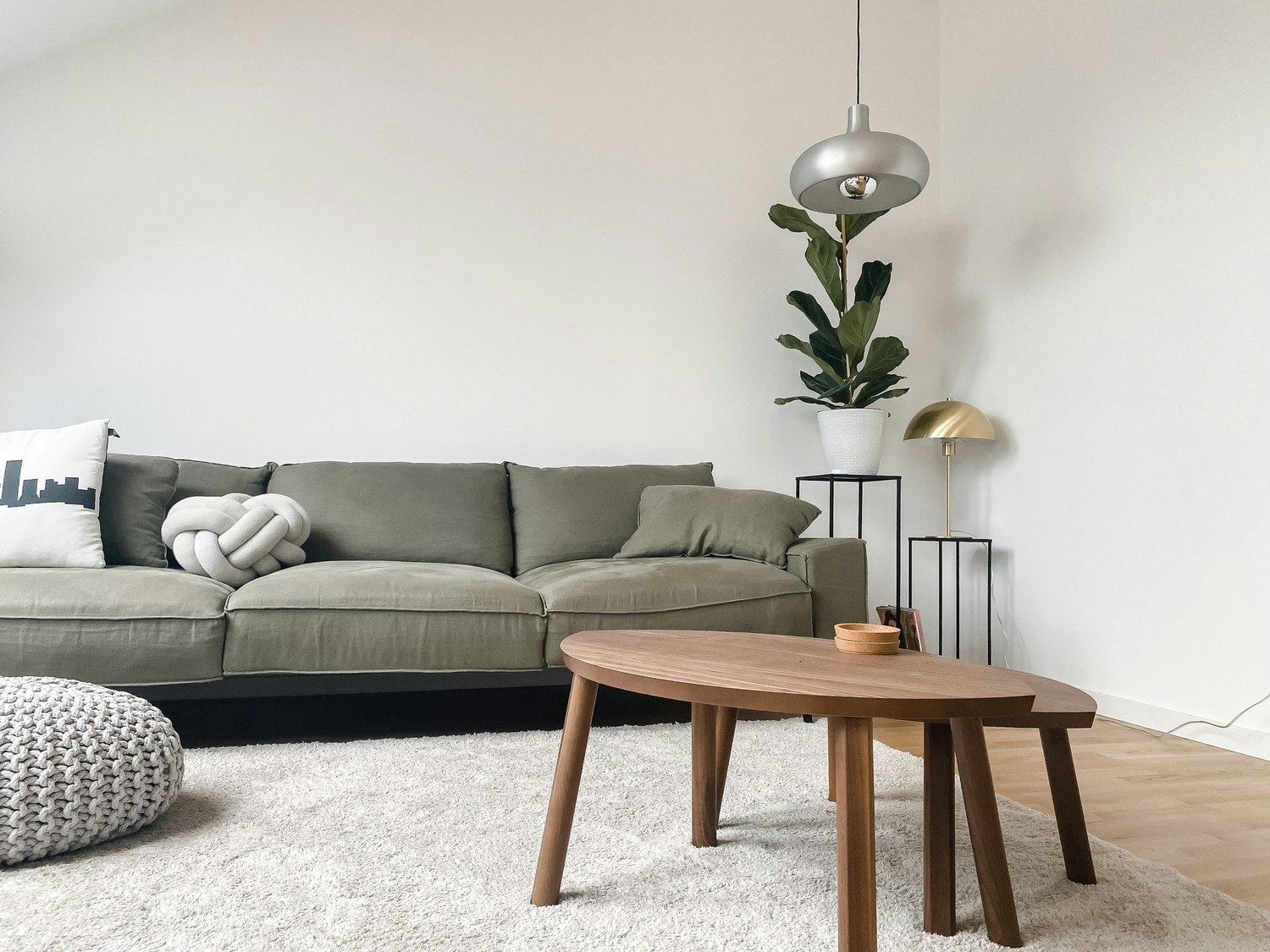 Minimalistyczny salon z zieloną sofą i drewnianym stolikiem fot. Unsplash