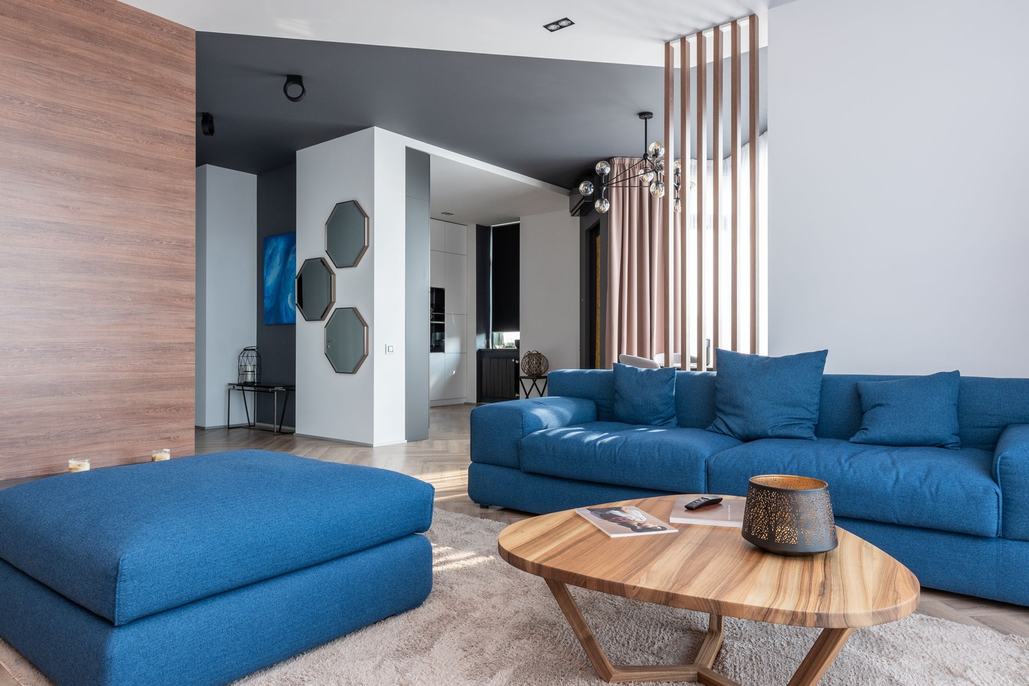 Nowoczesny salon z niebieską sofą i drewnem fot. Pexels