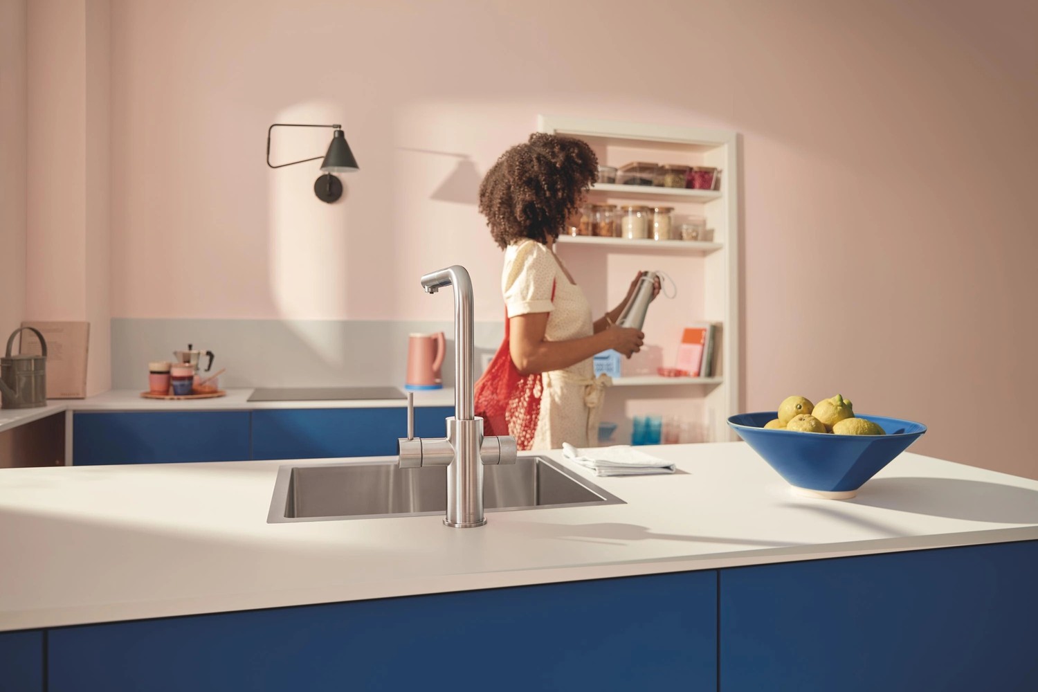 Niebieska kuchnia z wyspą i stalową baterią fot. Grohe