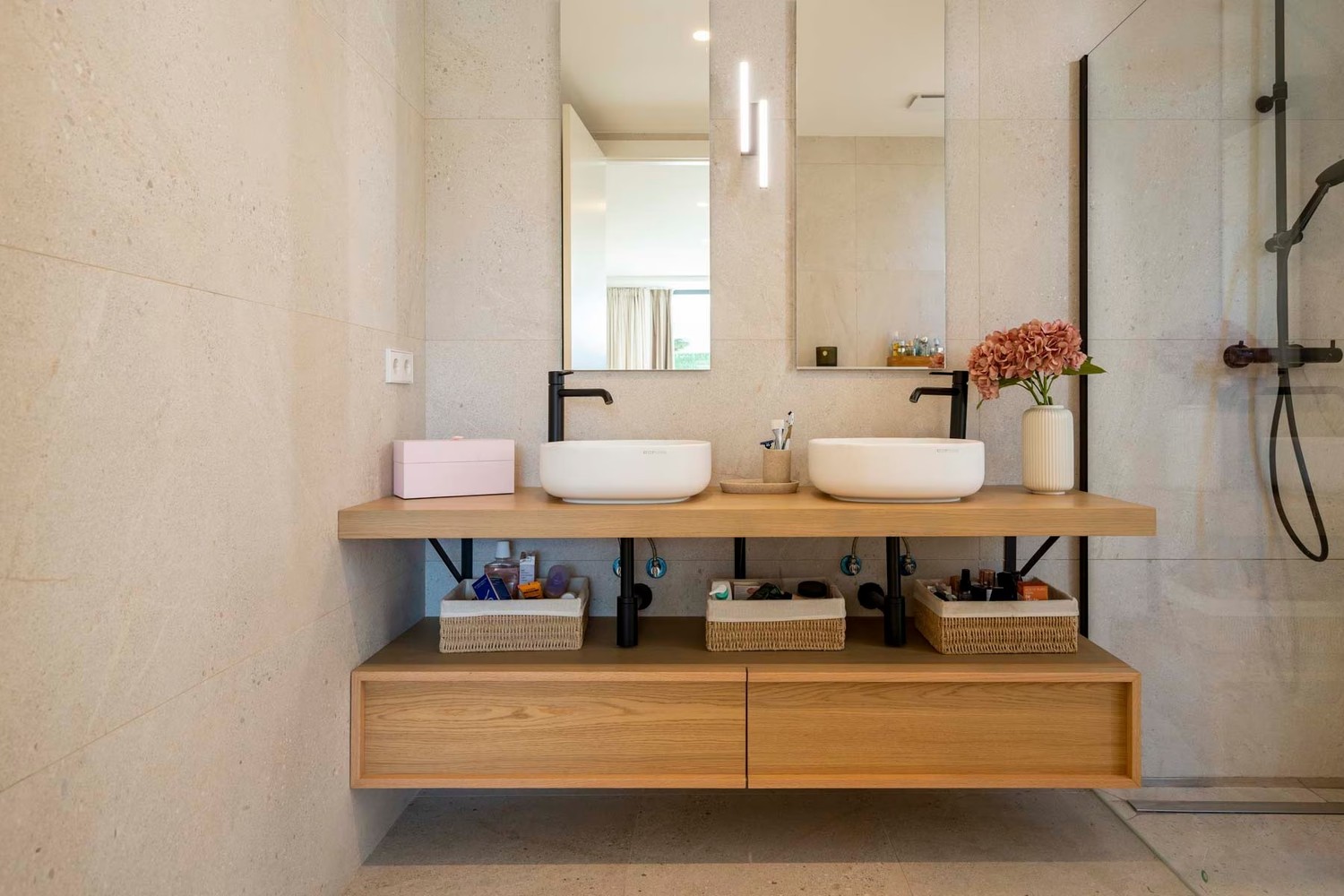 Minimalistyczna łazienka z dwiema umywalkami i drewnem. fot. Porcelanosa