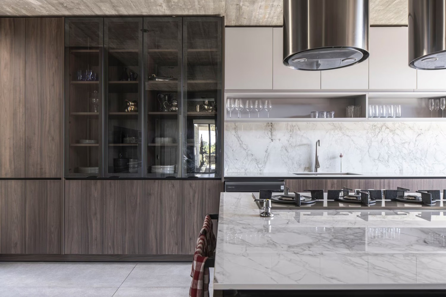 Minimalistyczna kuchnia z marmurową wyspą i drewnem. fot. Porcelanosa