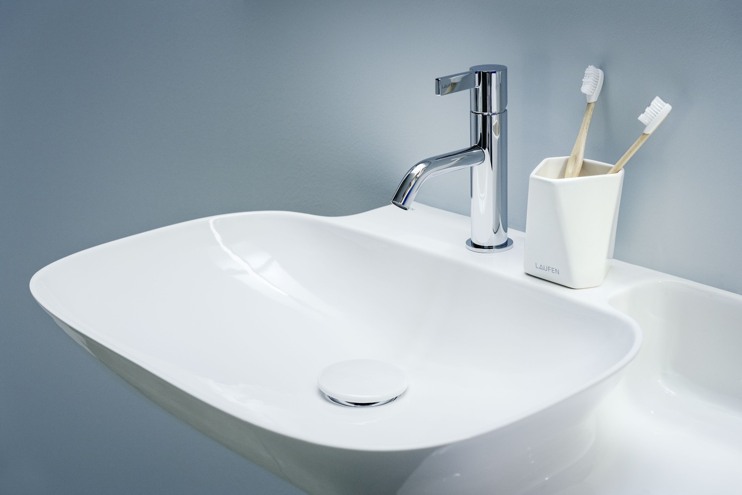 Minimalistyczna biała umywalka z chromowaną baterią fot. Laufen