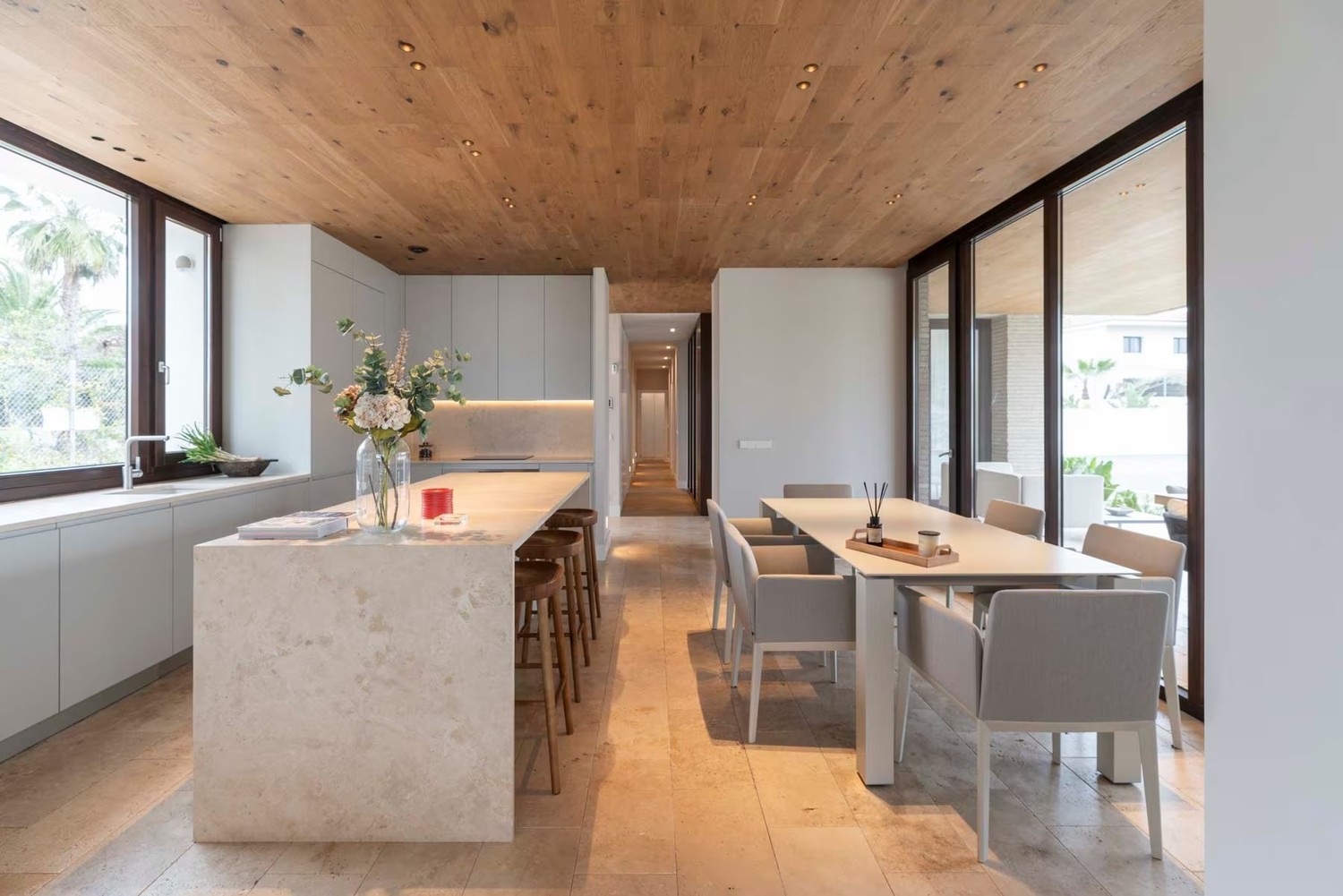 Minimalistyczna kuchnia z kamienną wyspą i jadalnią fot. Porcelanosa