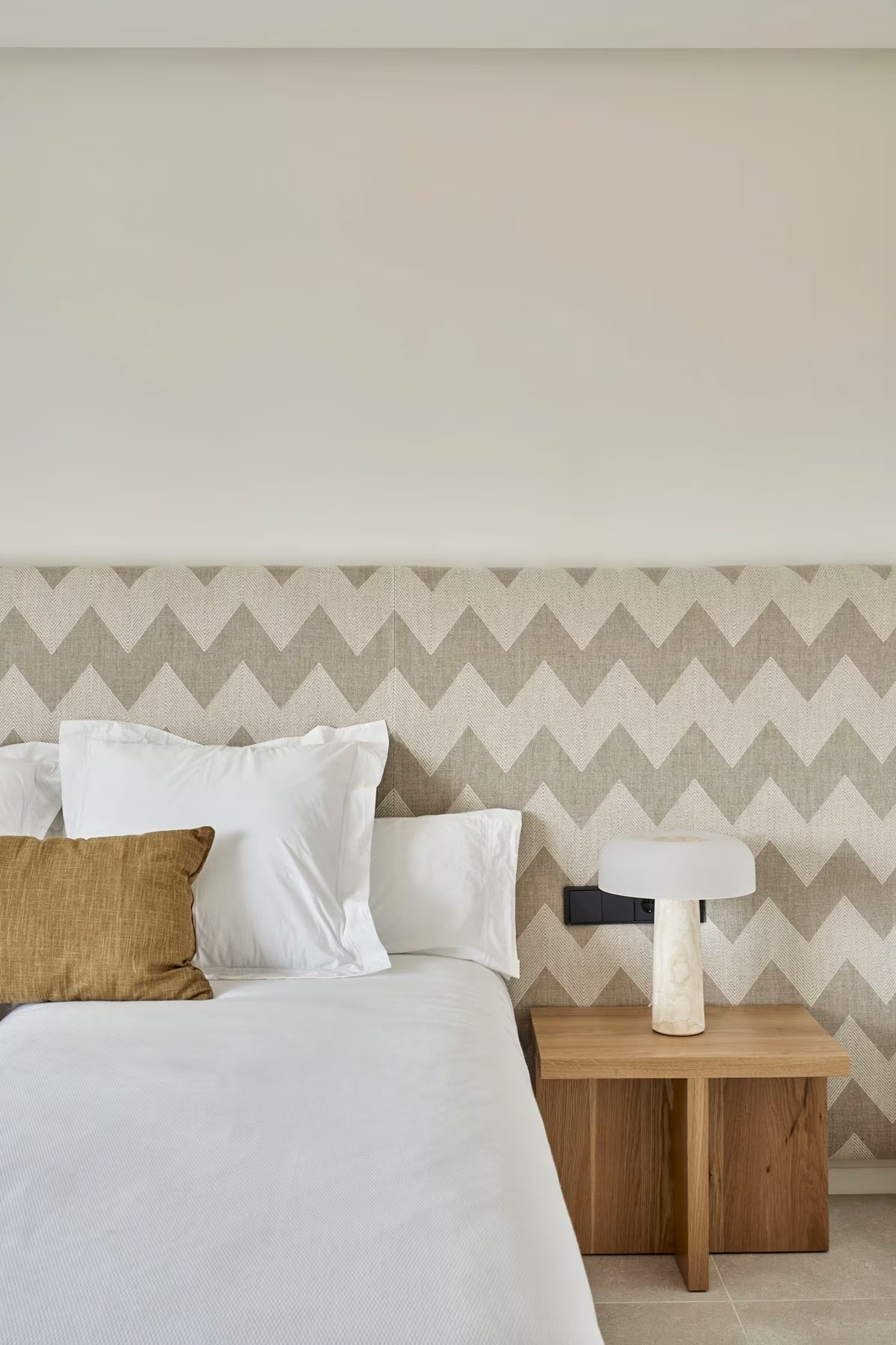 Beżowa sypialnia z tapetą i drewnem. fot. Porcelanosa