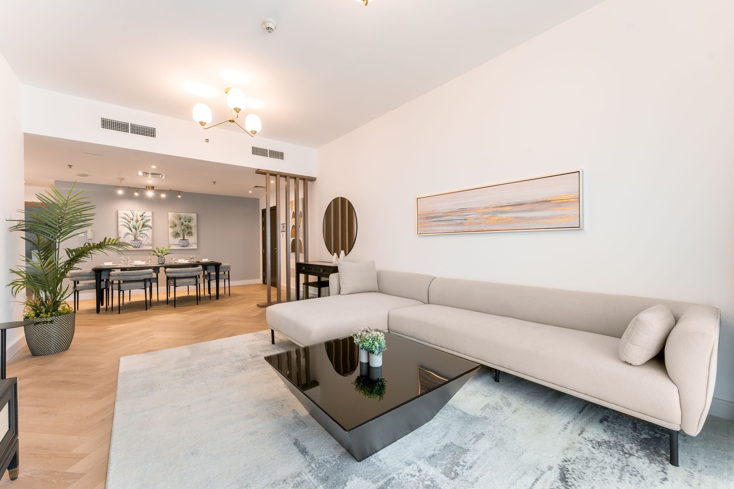 Nowoczesny salon z jadalnią, beżową sofą i dywanem fot. Pexels