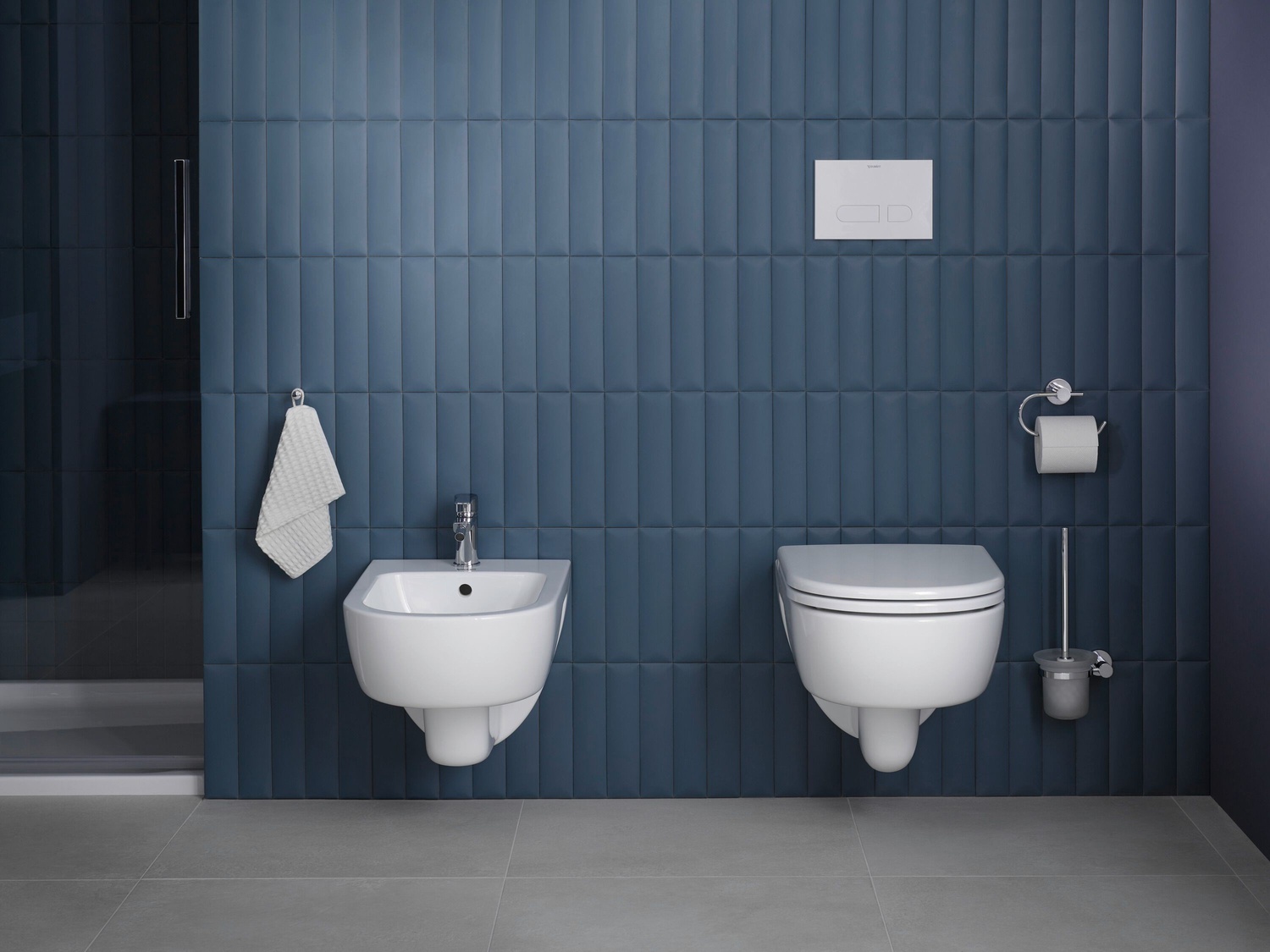 Biały bidet i WC na niebieskiej ścianie fot. Duravit