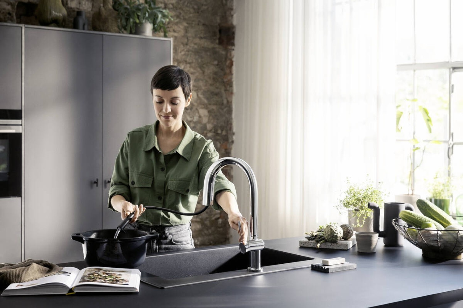 Kobieta przy nowoczesnym zlewie z baterią fot. Hansgrohe