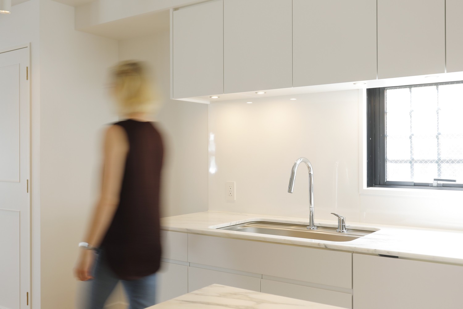 Minimalistyczna biała kuchnia z marmurowym blatem fot. Hansgrohe