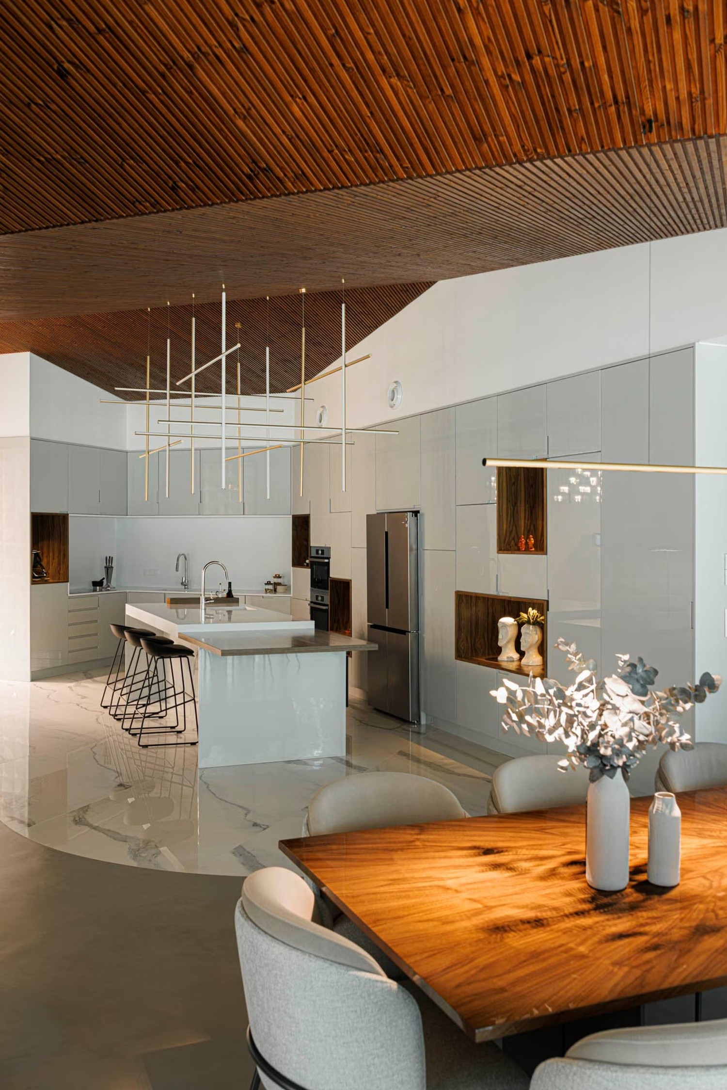 Minimalistyczna kuchnia z wyspą i drewnem. fot. Porcelanosa