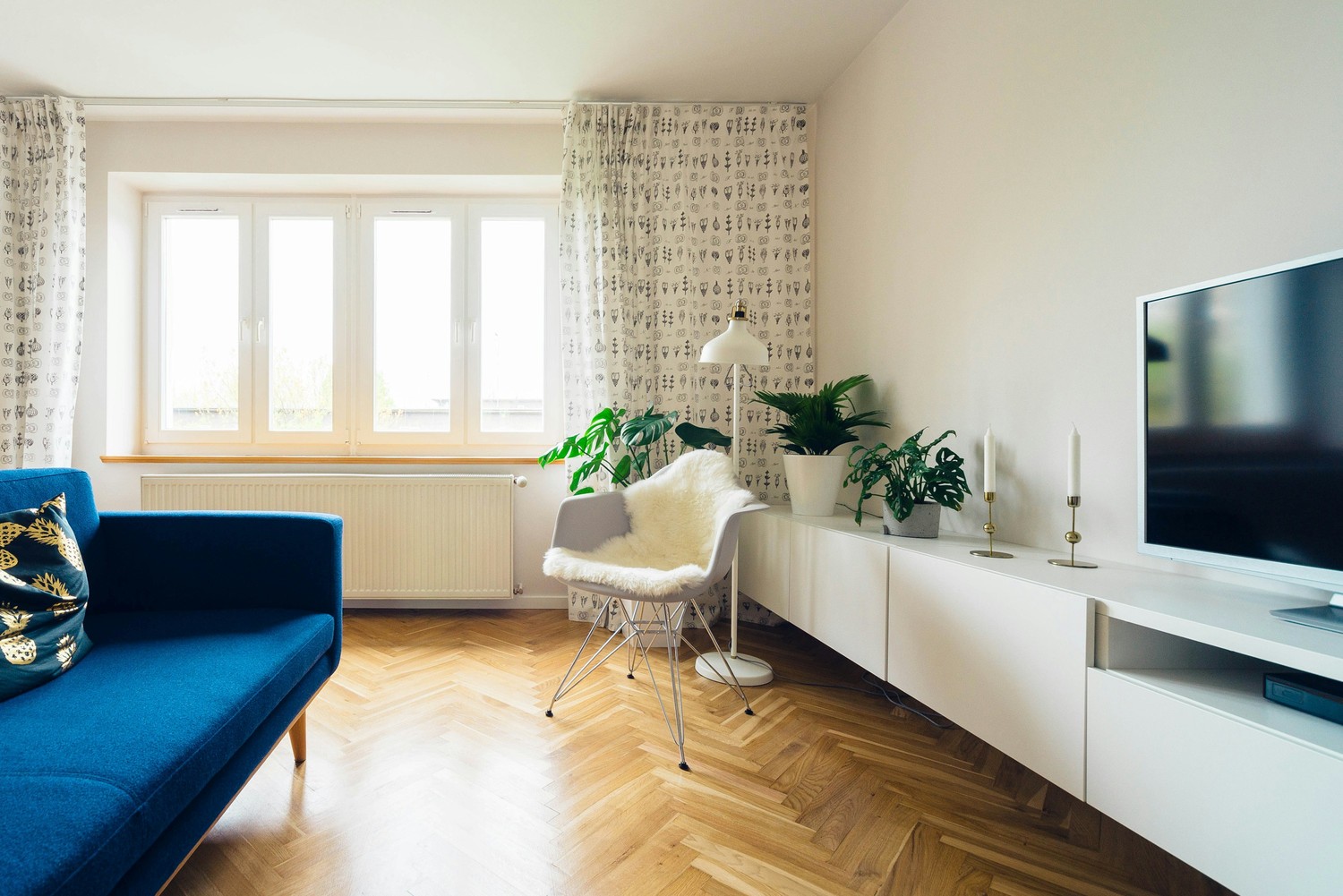 Skandynawski salon z niebieską sofą i rośliną fot. Unsplash
