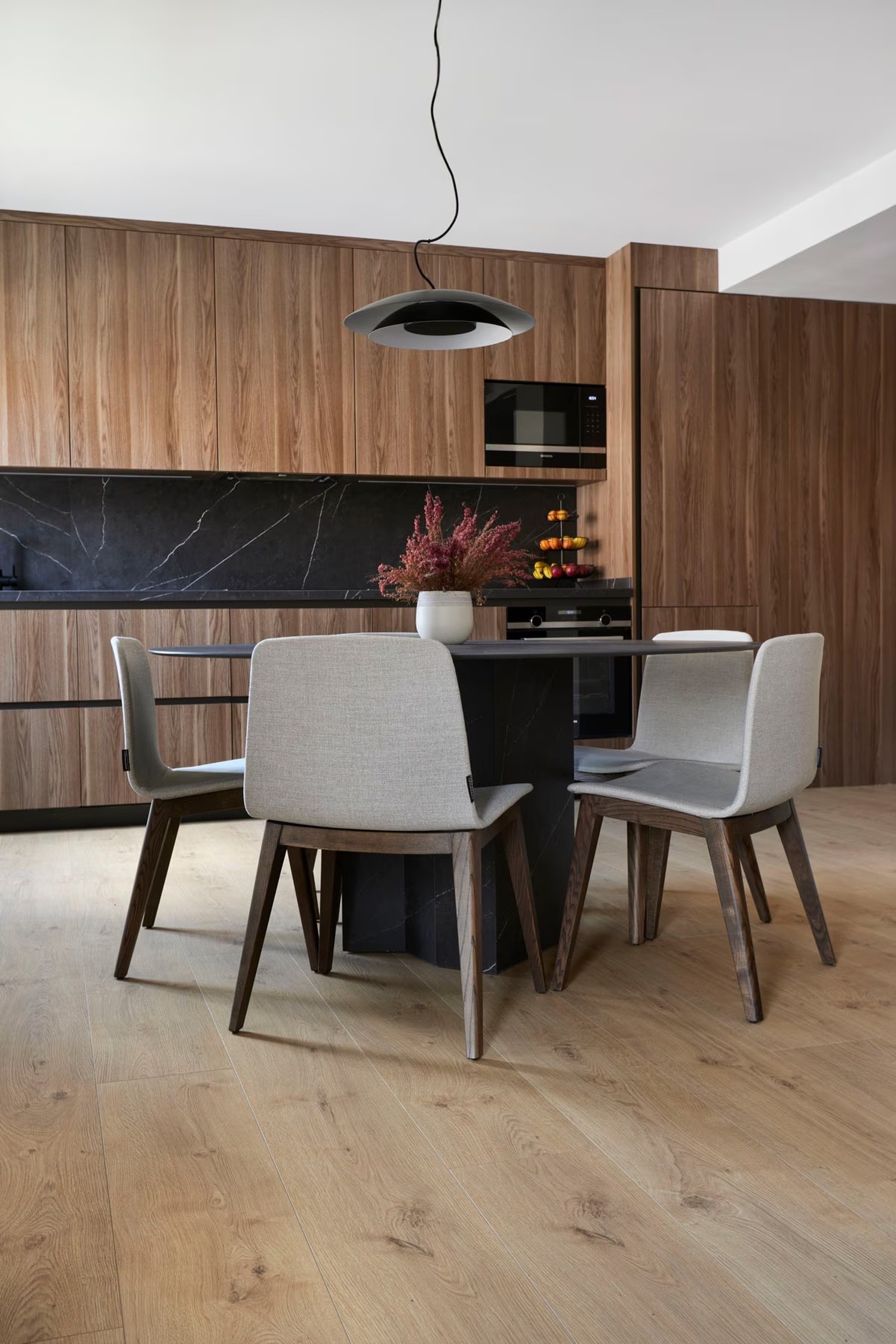 Minimalistyczna kuchnia z jadalnią w drewnie i czerni fot. Porcelanosa