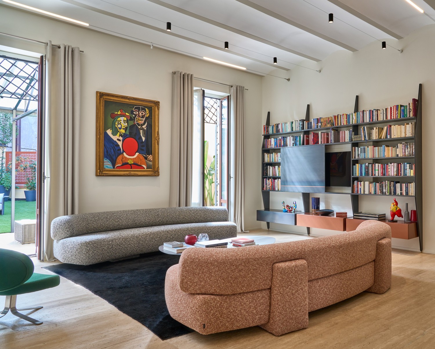 Eklektyczny salon z biblioteczką i miękką sofą. fot. Antrax