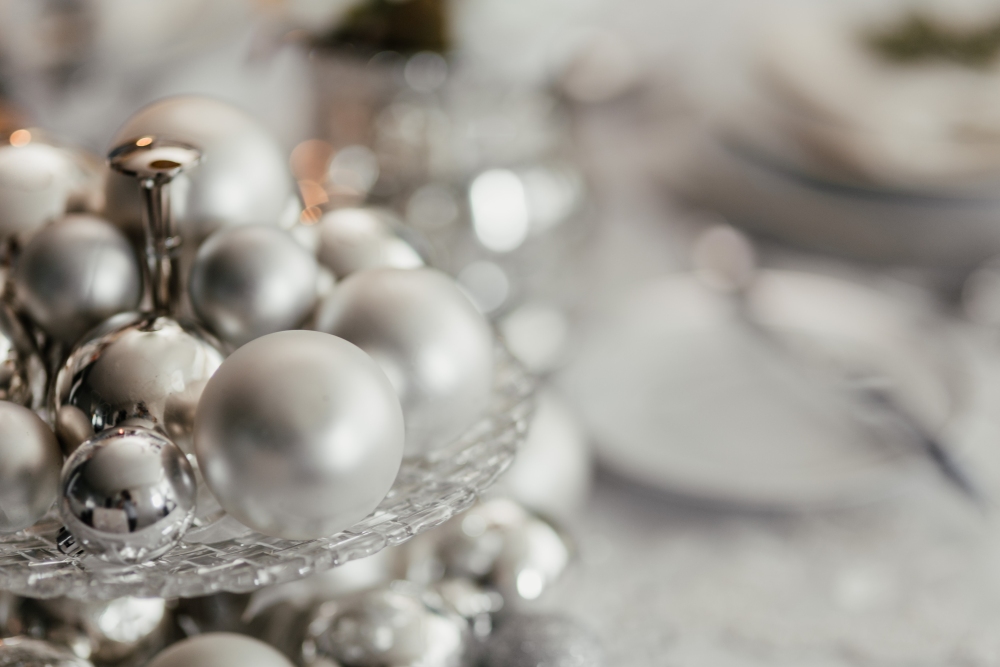 srebrne bombki na stole świątecznym, srebrny stroik na święta, święta w stylu nowoczesnym